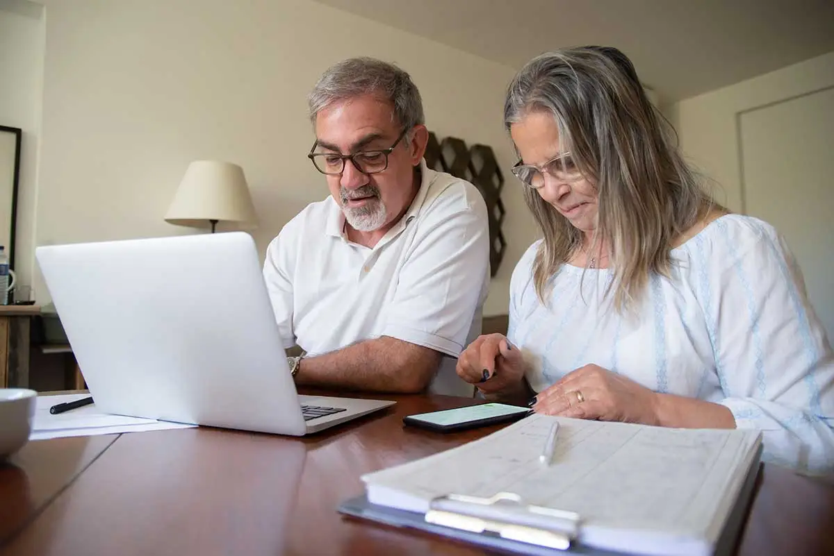 Couple researching life insurance on computer